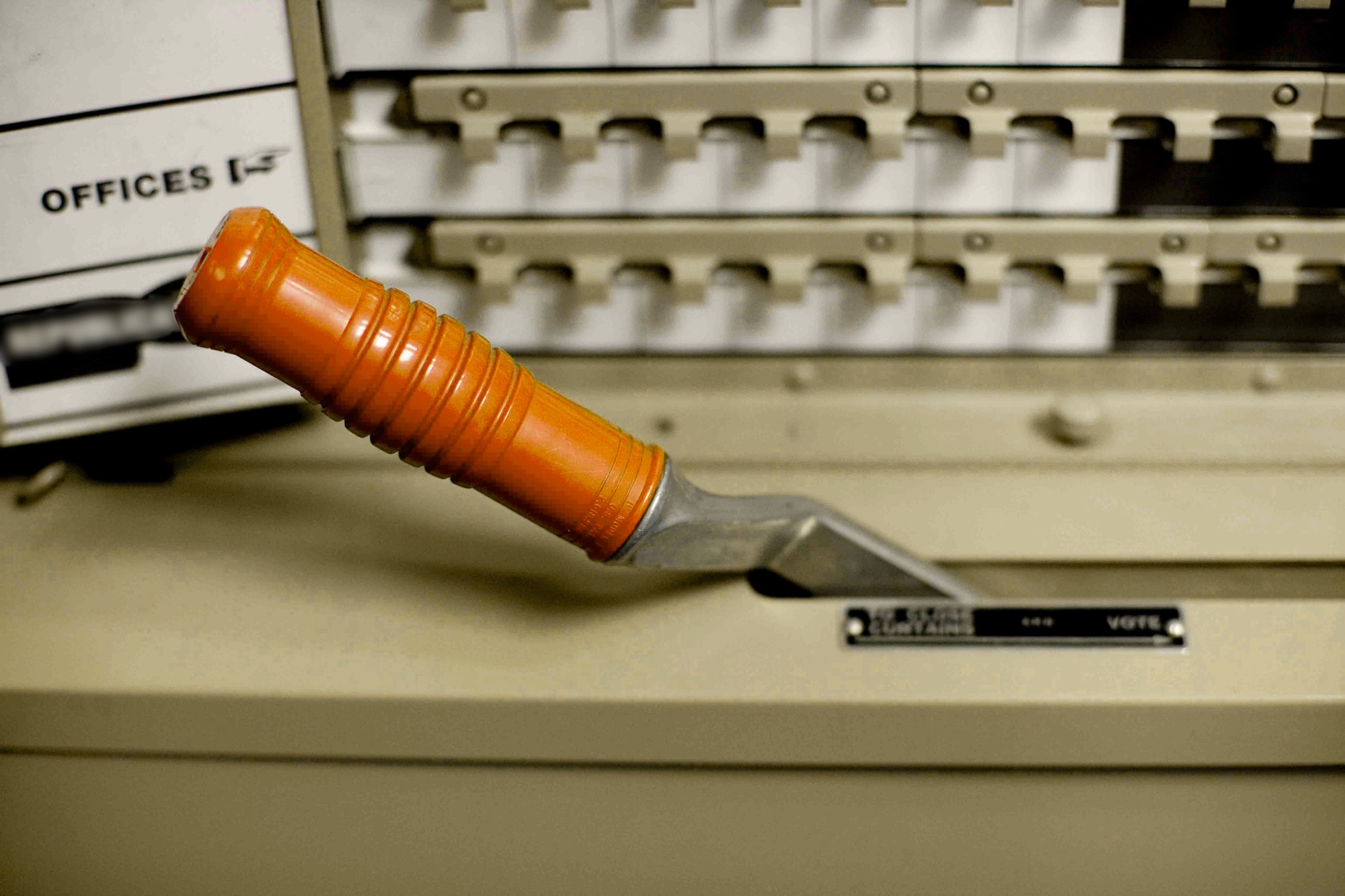 The lever of an old voting machine, next to a plate that reads VOTE